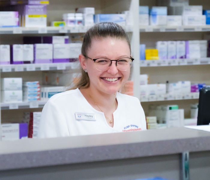 Stargate Shopping Centre Leasing Opportunities a Chemist smiles in front of the counter in a pharmacy