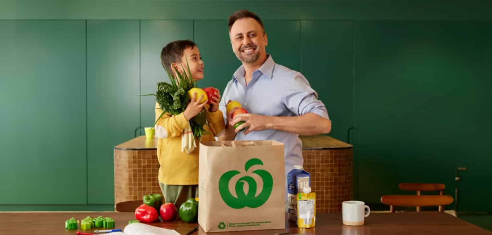 Dad and child smile at camera whilst unpacking groceries from Woolworths at Stargate Baldivis